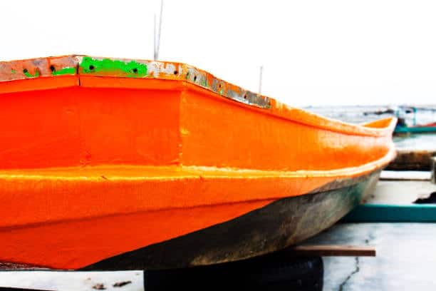 Close-up of a brightly painted boat on land, symbolizing maintenance or repair delays that can contribute to demurrage in maritime operations.