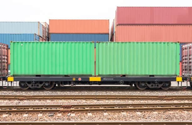Two 20-foot shipping containers transported by rail, representing multimodal shipping options to India.