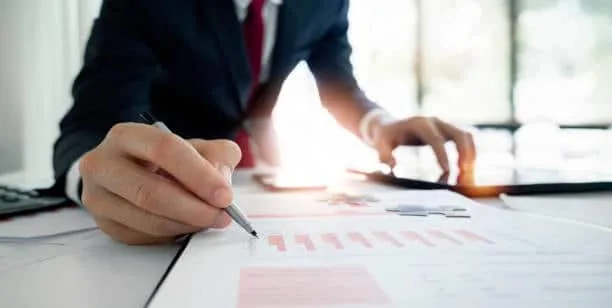 Close-up of a businessman analyzing financial data and customs documents, highlighting the detailed assessment required for effective customs clearance.