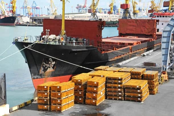 Heavy freight cargo in wooden crates staged for low-cost sea shipping.