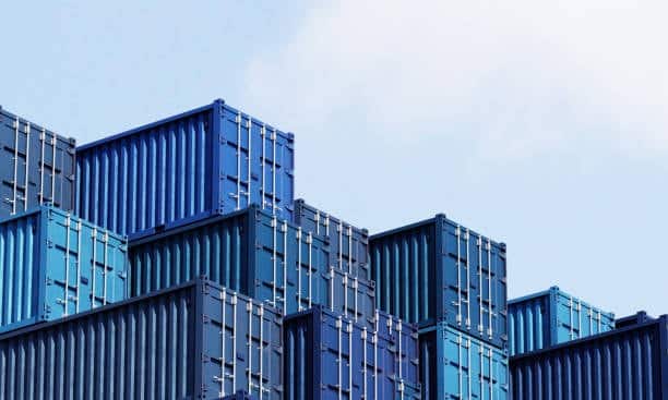 Neatly stacked blue shipping containers prepared for inspection and processing as part of the customs clearance workflow.
