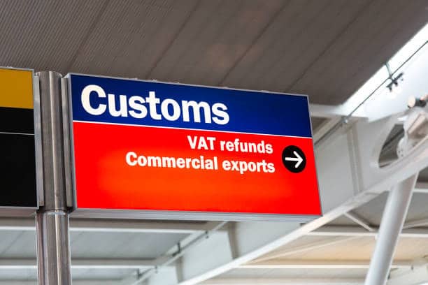 Airport customs sign with directions for VAT refunds and commercial exports, representing customs clearance and tax-related procedures for importing from China.