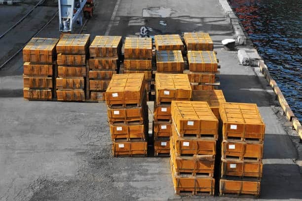 Large stacks of wooden crates containing heavy items ready for port loading.