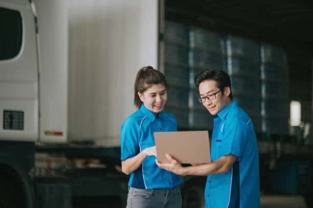 Logistics team in Malaysia reviewing shipping documents for UK delivery.