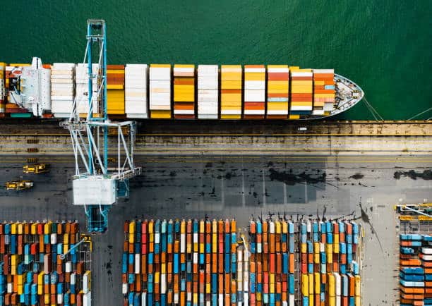 Aerial view of a container vessel being loaded at a US port for shipment to New Zealand.