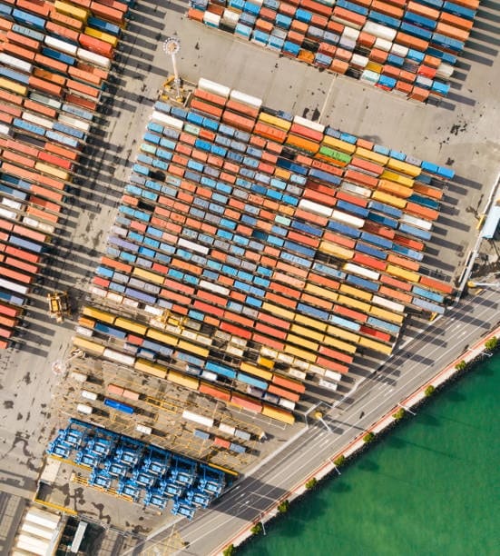 Top-down view of colorful shipping containers at a US port ready for export.
