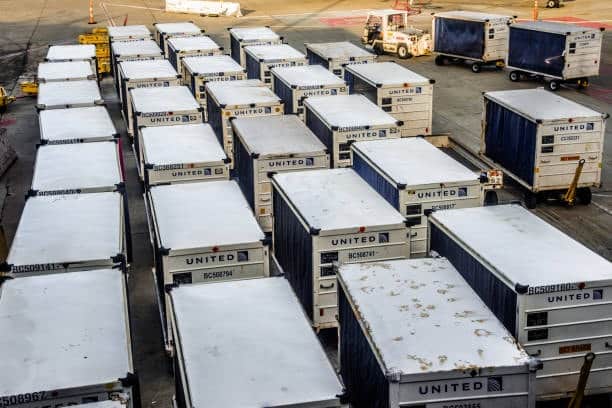 Air freight containers lined up for customs clearance at airport terminal.