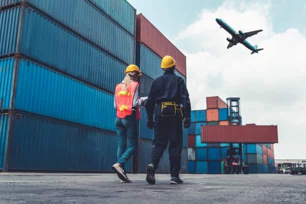 Airplane flying over stacked containers, symbolizing multimodal international shipping.