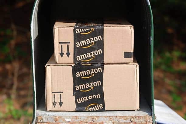 Two Amazon packages placed inside a mailbox with branded black Amazon tape.