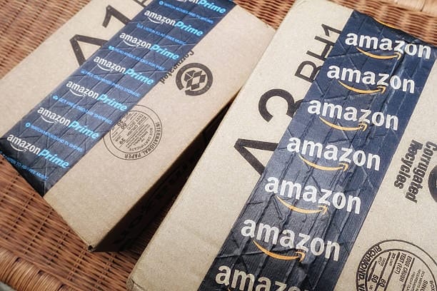 Two Amazon boxes with corrugated recycle symbols and FBA-compatible barcode zones.