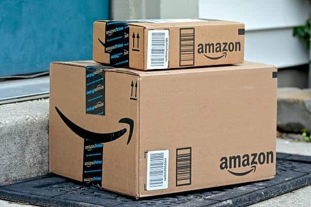 Amazon shipping boxes with barcode labels and Prime tape placed on doormat.