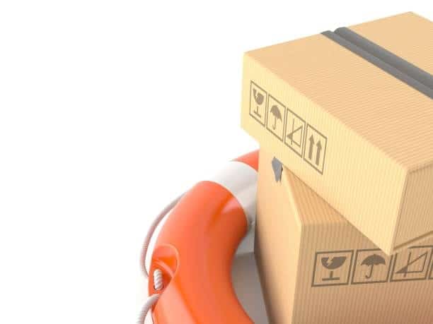 Cardboard shipping boxes placed on a lifebuoy, symbolizing cargo insurance, risk management, and financial protection from detention and demurrage charges.