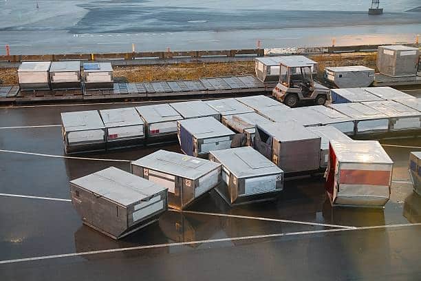 Air cargo containers positioned for customs inspection at airport.
