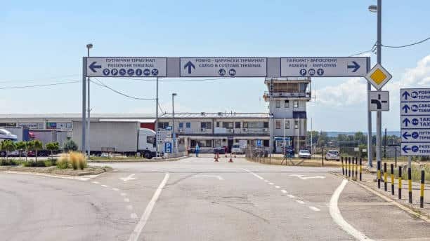 "Directional signs for cargo and customs terminal at an international border checkpoint.