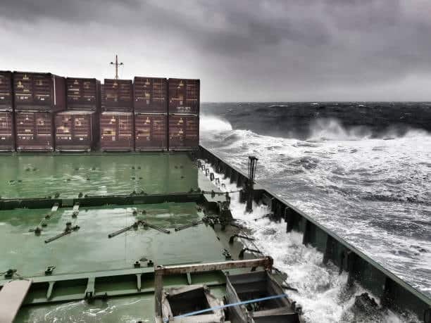 View from cargo ship deck facing rough sea and stormy skies, highlighting how severe weather can cause shipping delays and lead to demurrage fees.