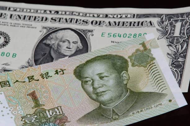 Chinese yuan and US dollar notes representing exchange rates and customs fee calculations on imports from China to the USA.