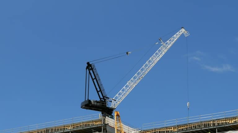 Industrial crane at a construction site symbolizing logistics and shipping infrastructure growth.