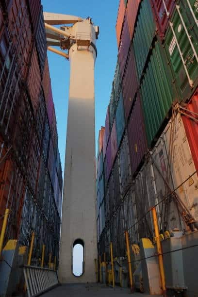 View of shipping containers on a vessel deck, showing sea freight stage in port-to-door shipping service.