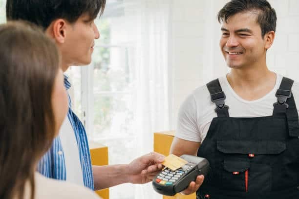 Seller receiving payment via card reader, illustrating buyer’s role under CPT shipping terms.
