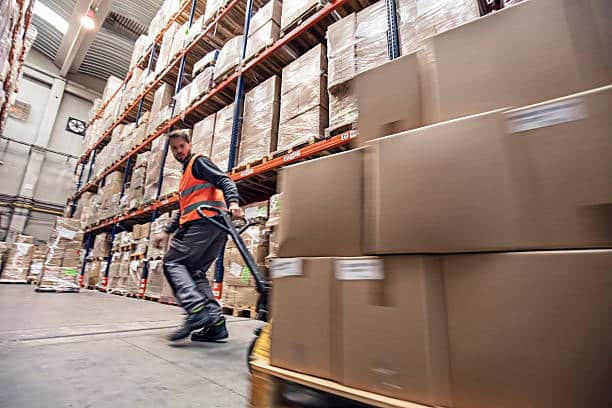 Warehouse worker handling shipments prepared for transport from Canada to the US.