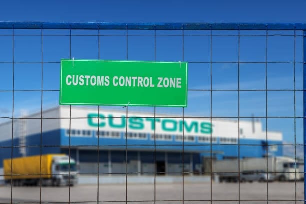 Trucks lined up in customs control zone awaiting clearance.