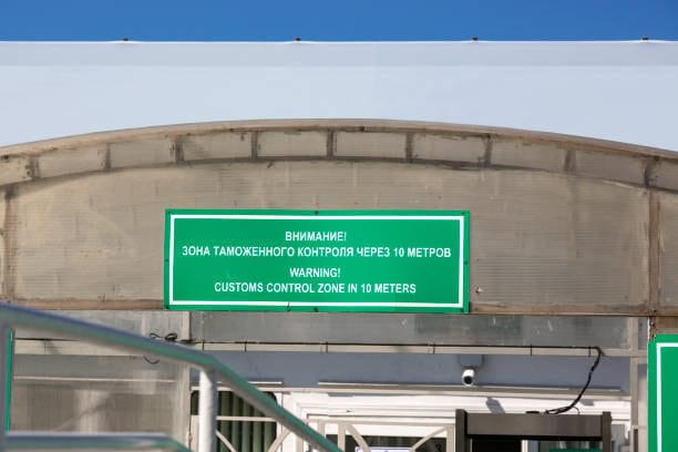 Warning sign for customs control zone ahead at international checkpoint.