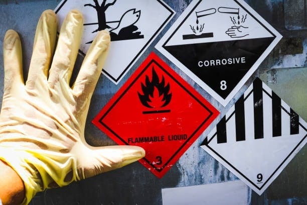 Close-up of UN hazard labels including flammable liquid, corrosive, and environmental hazard, essential for dangerous goods declaration.