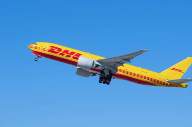 DHL Express cargo airplane in flight representing international air shipping from China to the USA.