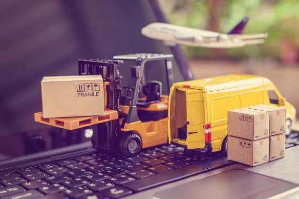 Conceptual image showing freight forwarding services with a forklift, delivery van, and airplane over a laptop keyboard, symbolizing modern logistics coordination.