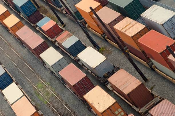 Rail cars carrying outbound shipping containers for freight delivery.