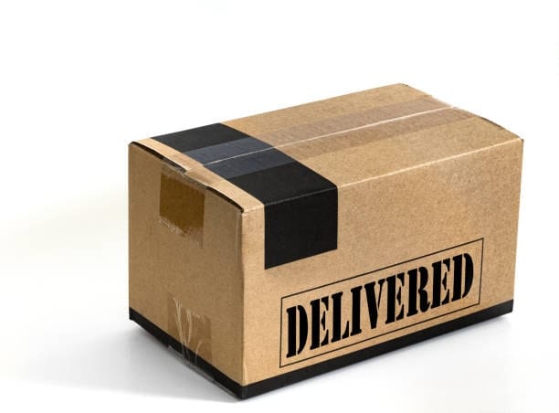 Plain brown cardboard box with black tape and 'Delivered' text, representing delivery completion.