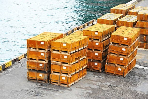 Heavy green crates stacked on dockside, ready for cost-effective sea freight shipping.