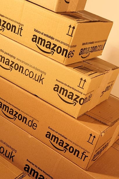 Stack of Amazon boxes from different regions showing multilingual packaging compliance.