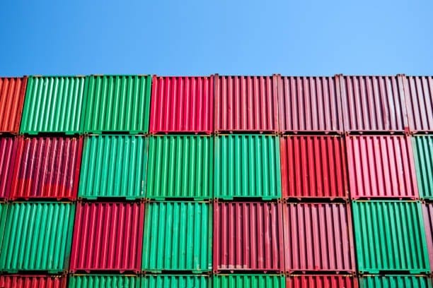 Rows of metal shipping containers stacked high for overseas export.