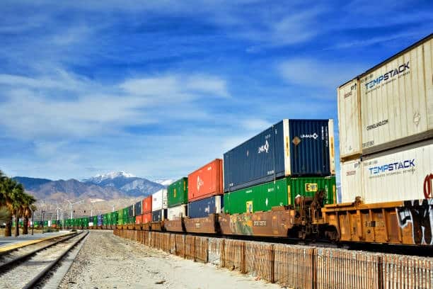 Long freight train transporting shipping containers for overseas export.