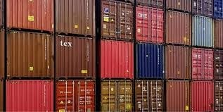 Stacked cargo containers awaiting COC certification for international shipping.