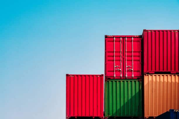 Green shipping containers stacked and ready for international transport.