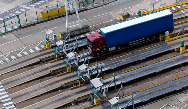 Cargo truck entering border checkpoint for customs clearance procedures.
