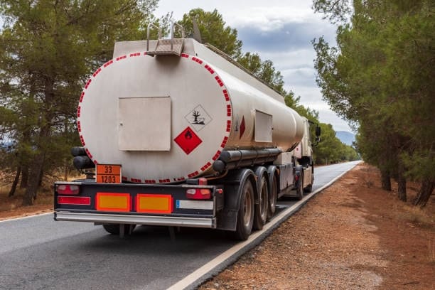 Tanker truck transporting hazardous and flammable goods on public road.