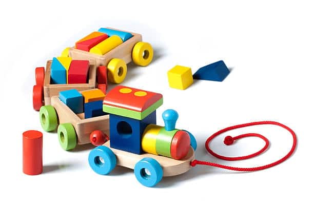 Colorful wooden toy train and blocks representing toy imports and safety compliance.