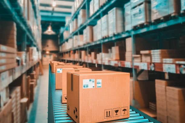 Shipping boxes moving through a warehouse, symbolizing import costs from France.