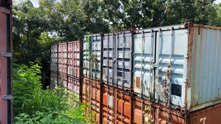 Used shipping containers stacked in outdoor yard