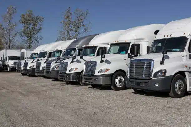 Line of white trucks used for COC container shipping